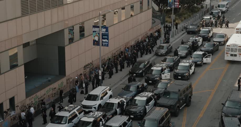 The police have the protesters lined against the building as they are being arrested