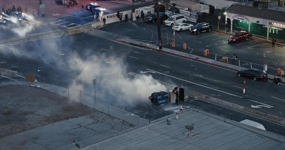 Law enforcement blocks access to a smoking dumpster while a responder works on dealing with the problem