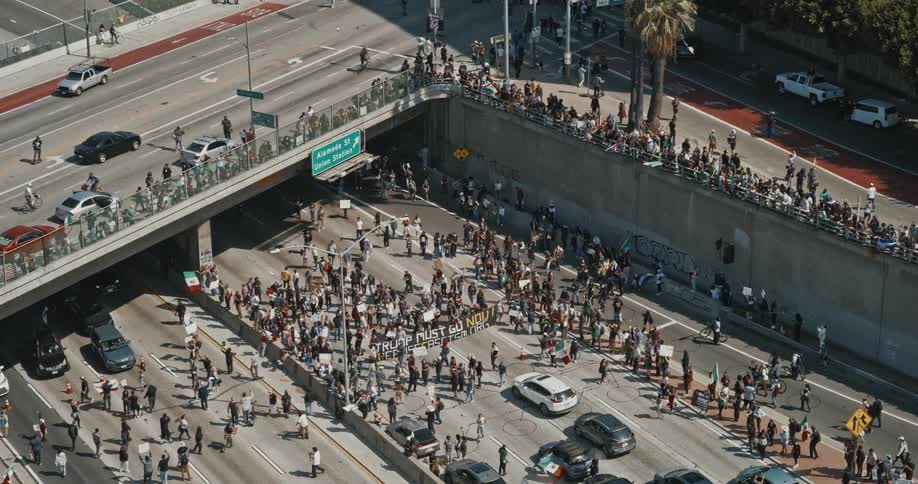 A crowd marches on a city freeway in protest seen from above