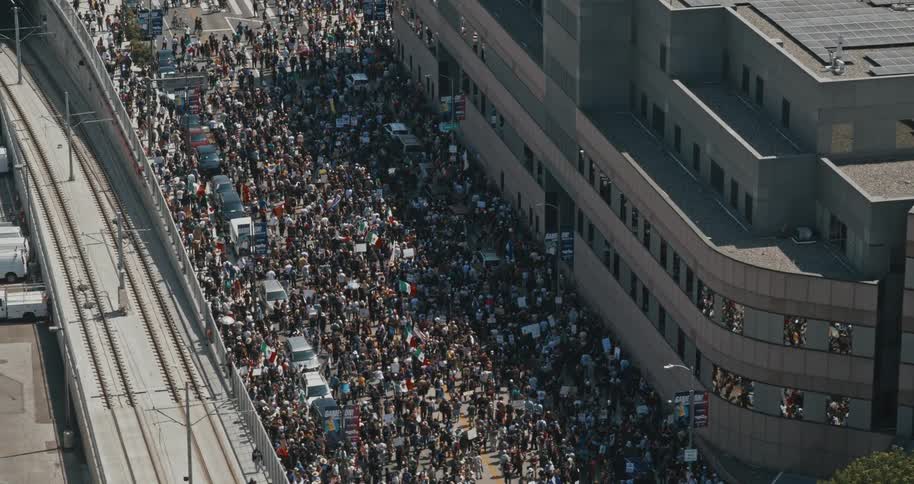 Protesting crowd fills a street during the daytime