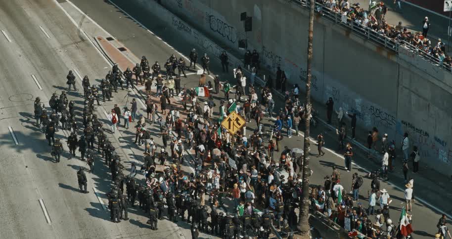 Protesters are encircled by police on a city highway during the day