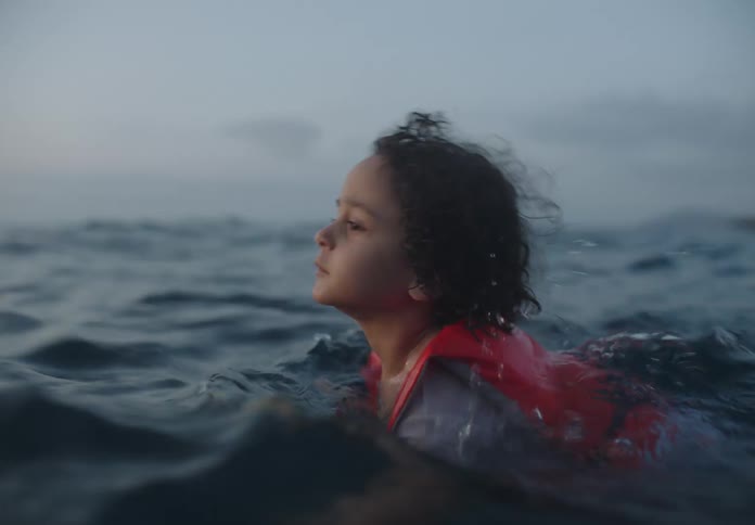 The boy is slowly swimming in the ocean