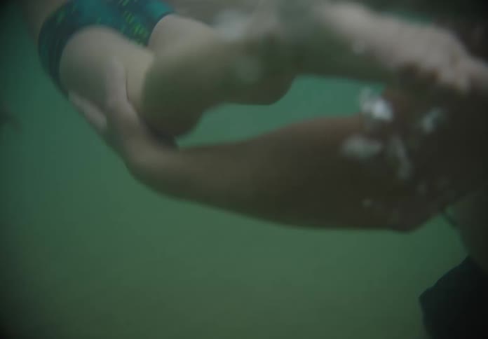 A father is teaching his son how to swim