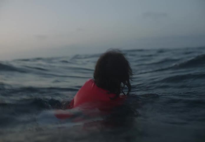 A child is swimming in rough waters