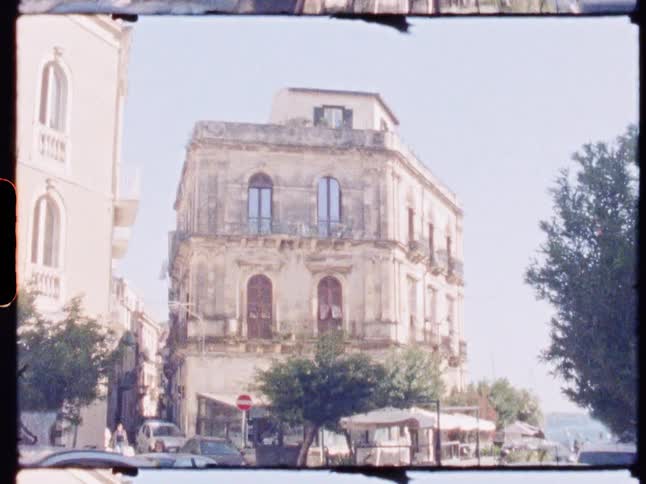 Cars pass the old buildings in the city