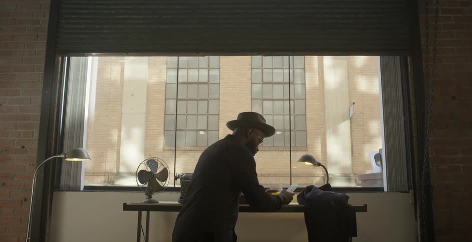A man stands in front of an apartment window