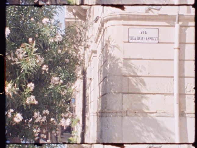 A quiet street corner with a building and street sign captured in soft vintage lighting
