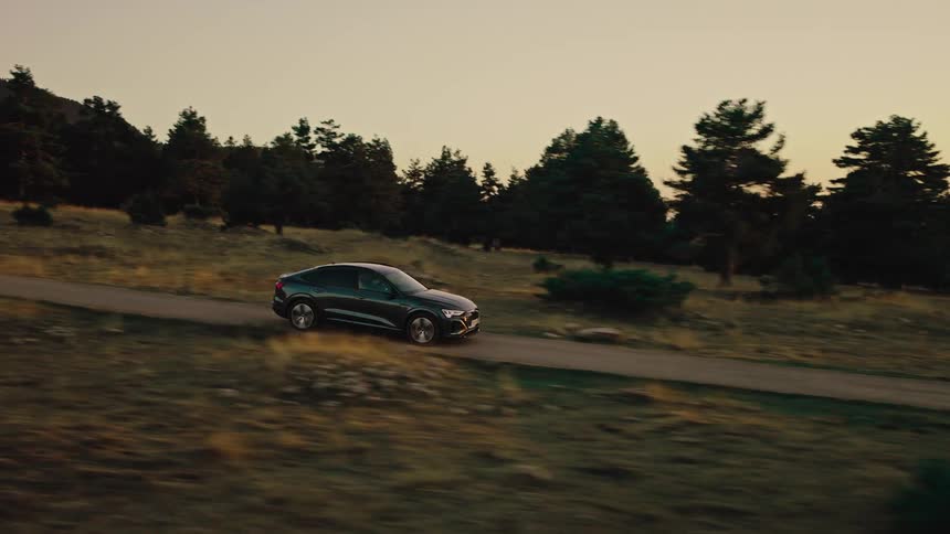 The car is moving on the small trail through the park