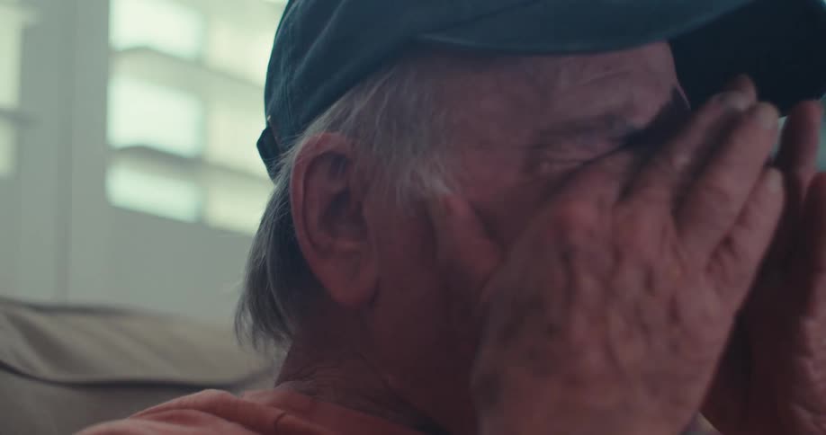 Elderly man is laughing and removes his eye glasses