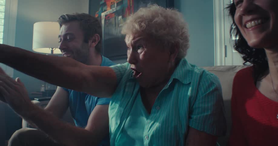 Two women hug as they watch television