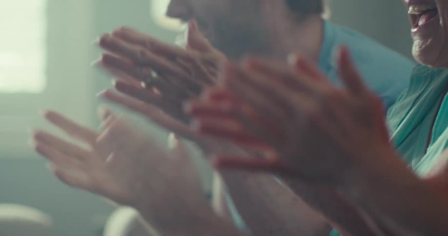 People clapping with joy in a close indoor setting