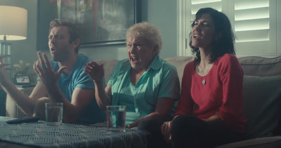 Three people are reacting to the television