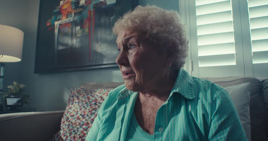 A woman is sitting on a couch and having a conversation with someone