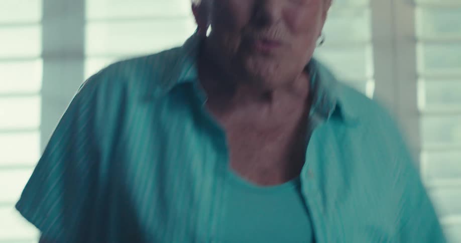Inside of her house an elderly woman is dancing