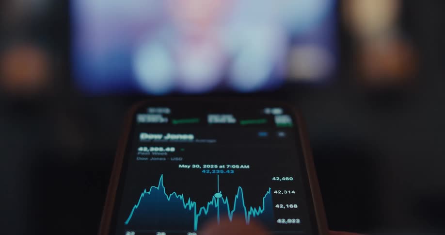 Close up of a phone screen as a person navigates a mobile trading interface while sitting in a living room