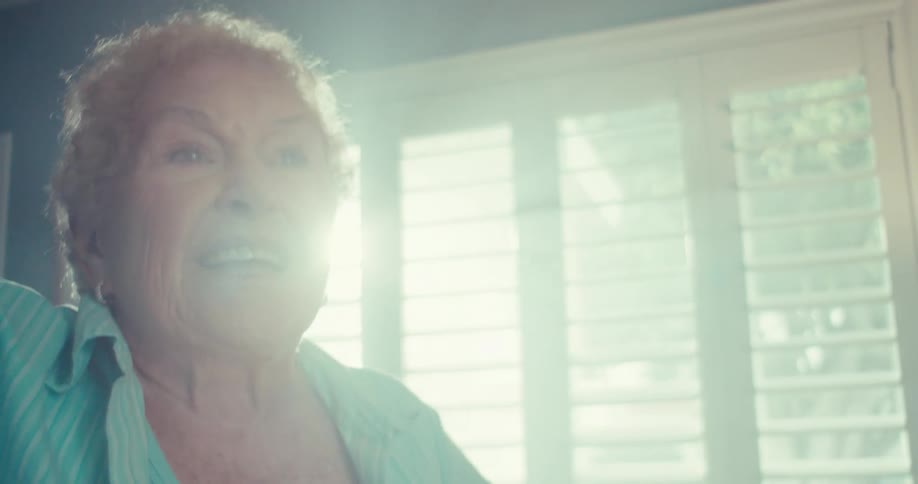 The woman is spinning and dancing by the window