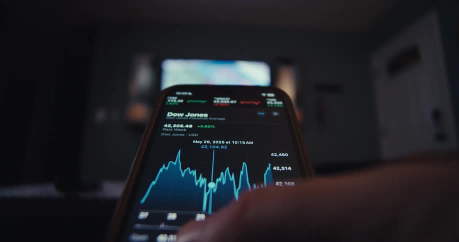 Close up of a person navigating a trading interface in a mobile phone app in the living room