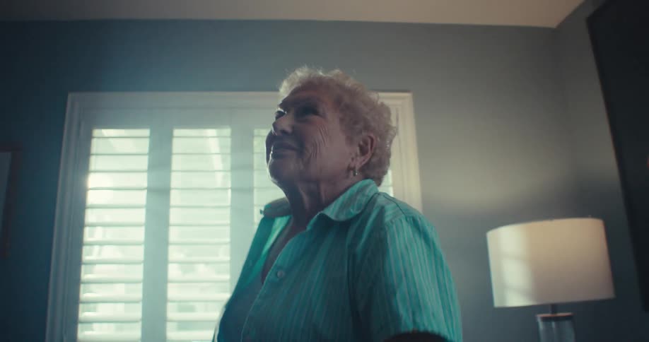 Elderly lady standing in living room dancing happily