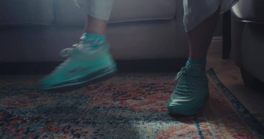 An elderly woman enthusiastically practices dance indoors in vibrant sneakers