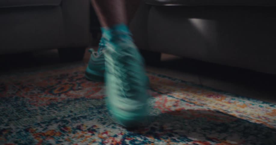 Close up of an elderly womans legs as she dances while standing in a living room
