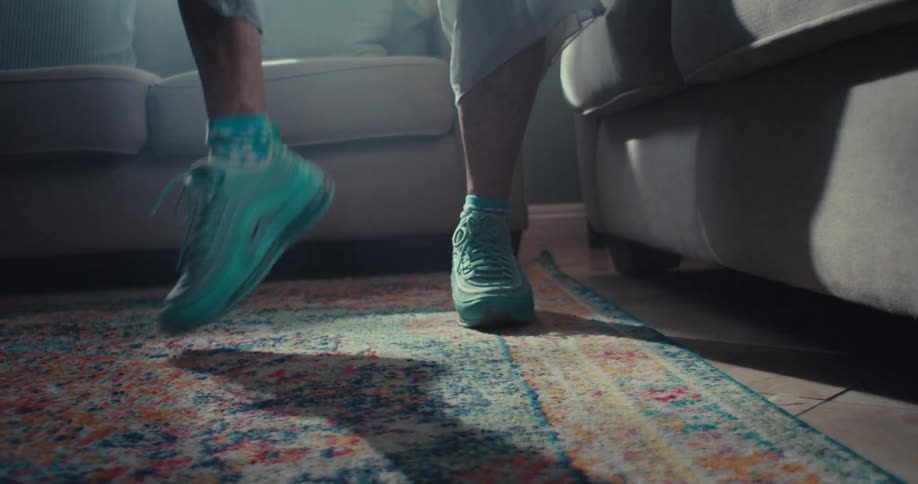 Close up of an elderly womans legs as she dances while standing in a living room