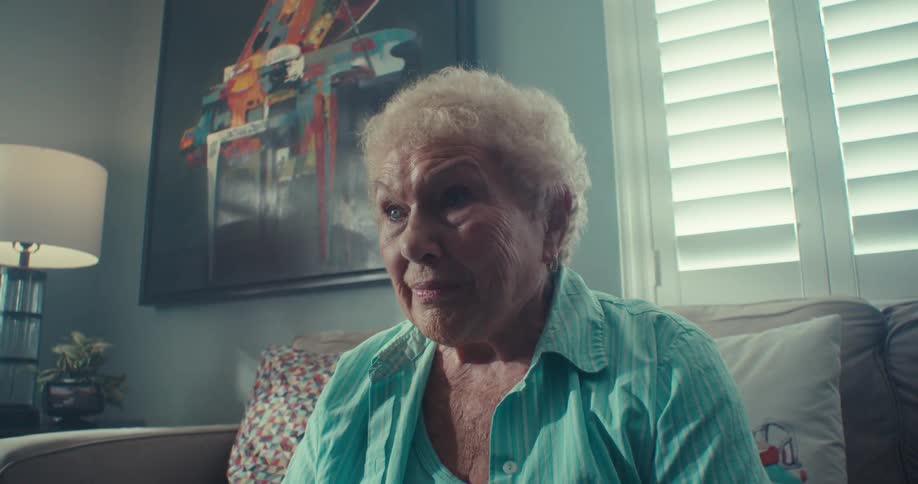 Elderly lady sitting on sofa in living room
