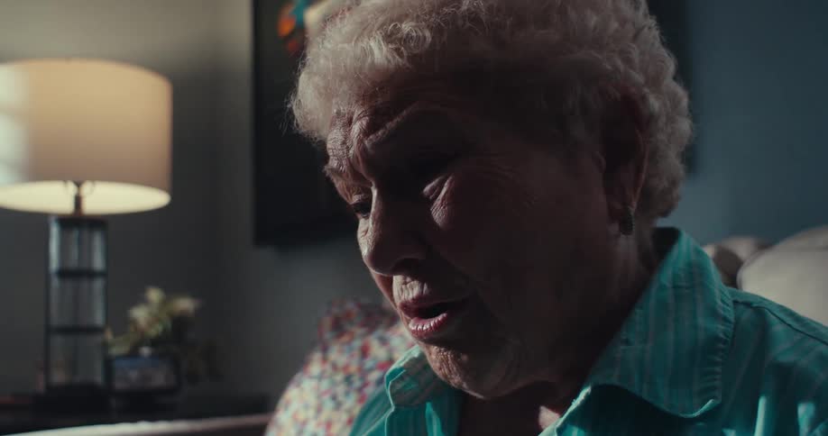 A woman looks concerned as she talks at home