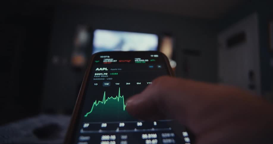 Close up of a person navigating a trading interface on a mobile phone application in a living room