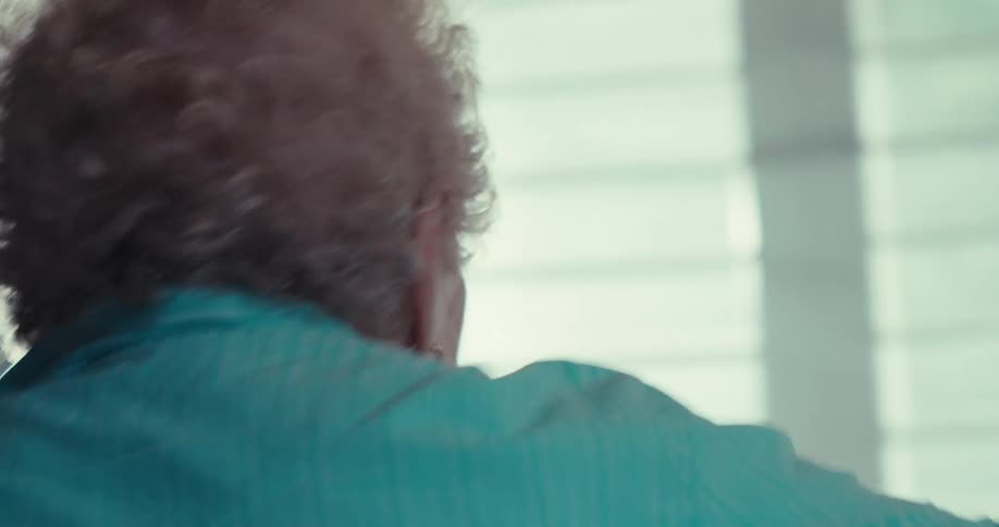 Elderly woman spins while happily dancing in a living room