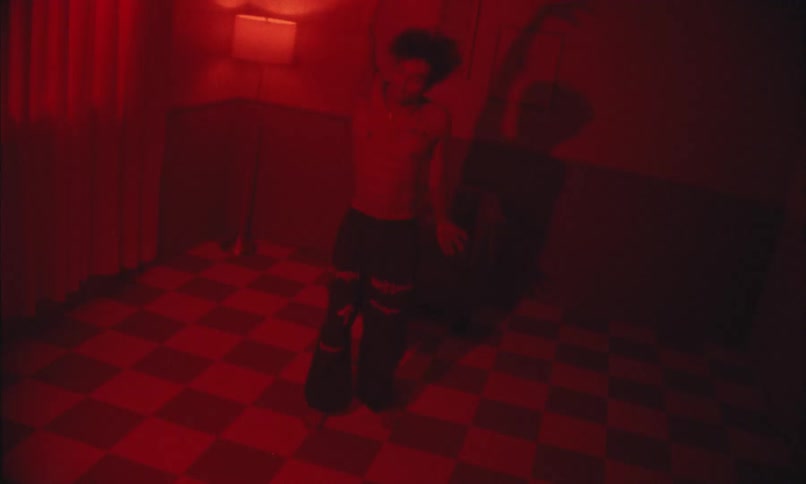 Silhouette of a person dancing in a red light room