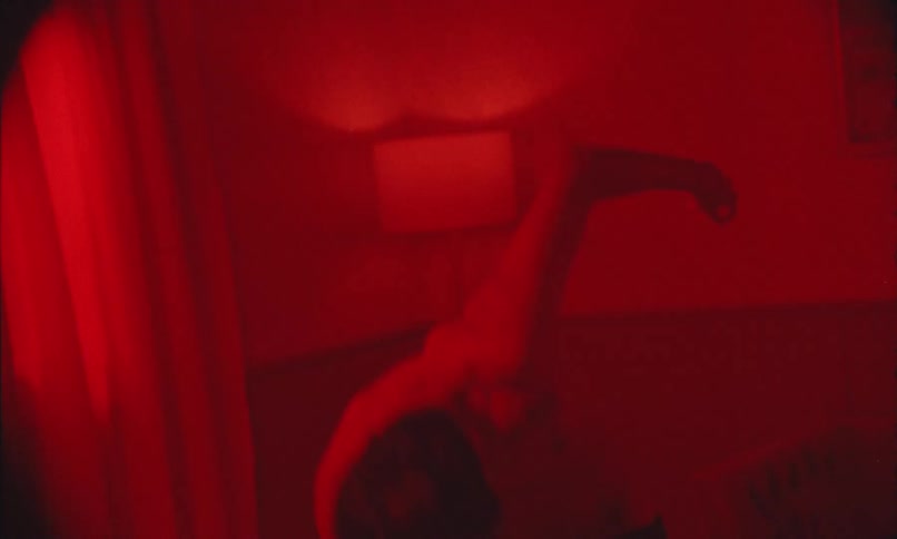 A shirtless man is waving his arms around while dancing