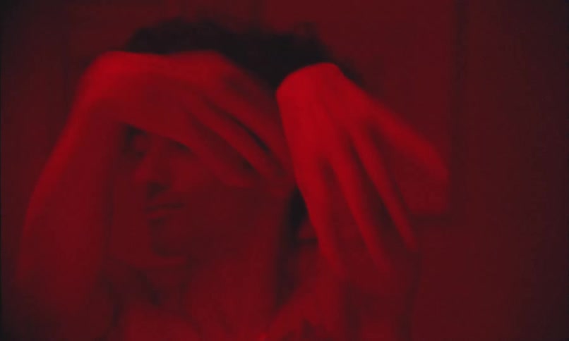 Man moving his hands in a room with red lighting