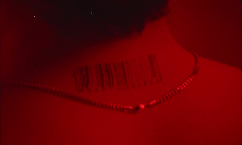 The back of a persons neck with a barcode tattooed on