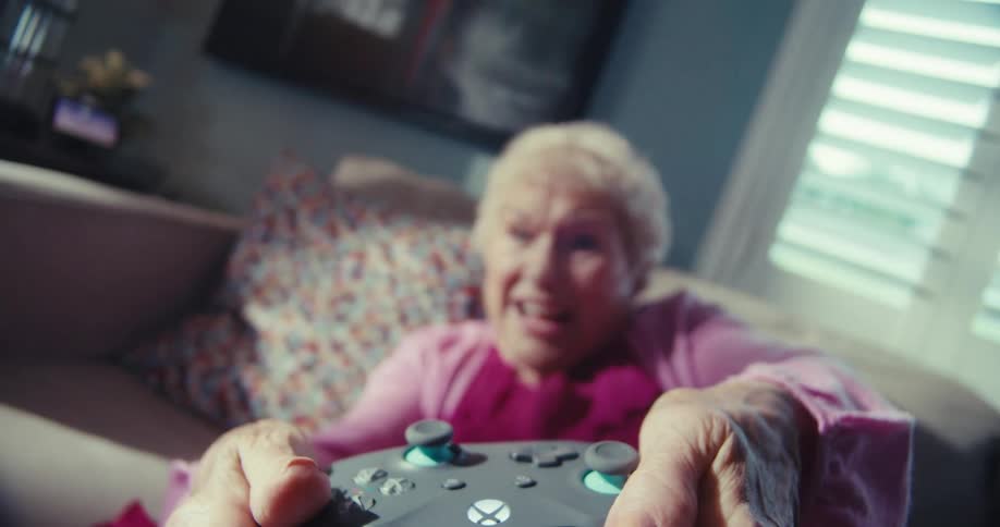 Elderly lady having fun playing video games and holding a controller