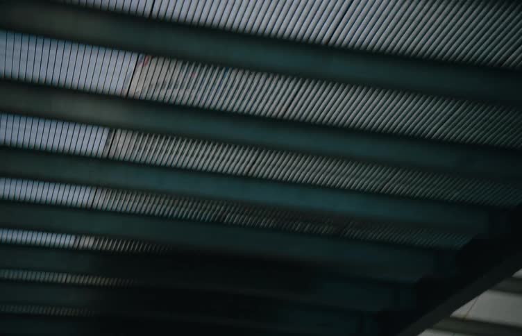 Car accelerates on a metal bridge in a city during the day
