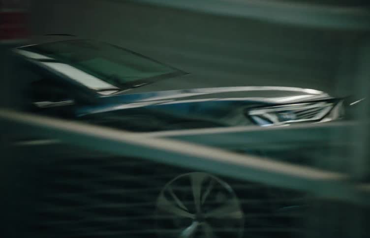 A car is driven upwards to a metal platform by man