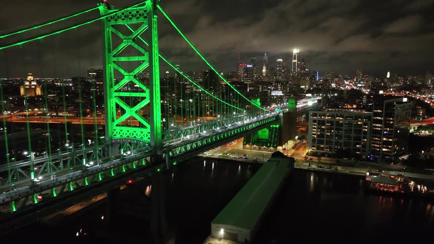 The Benjamin Franklin Bridge in Philadelphia is covered in green light