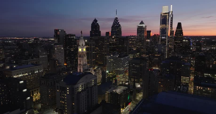 Aerial view of Philadelphia skyline at dusk with highrise buildings lit up