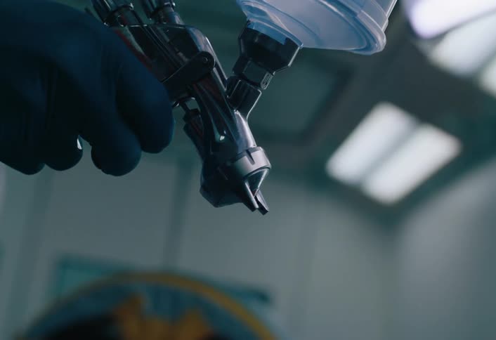 Gloved hand handling a spray device