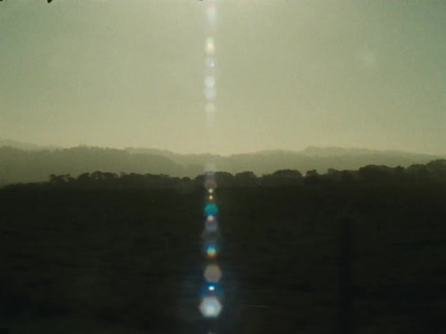 The sun glares over the dark field