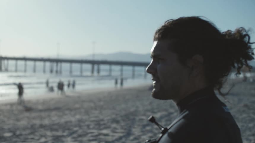 Man standing on the beach looking out at the water