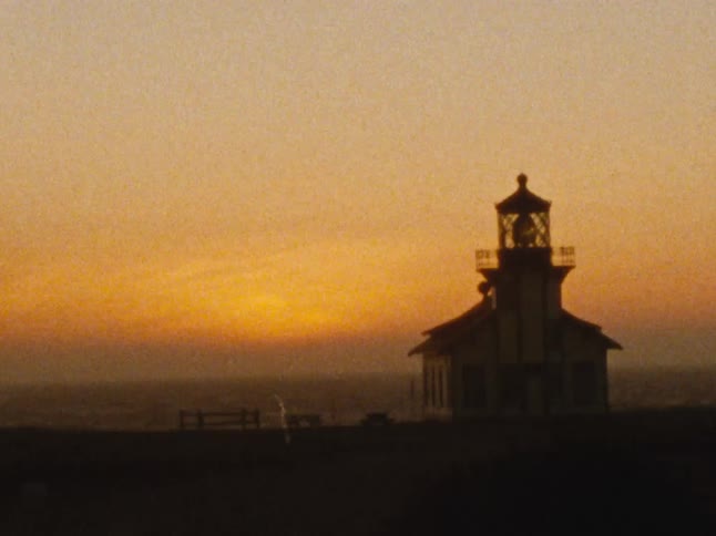 Religious building in a field by the sea shore at sunset