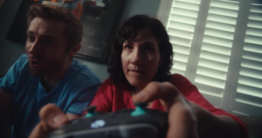 Man interferes while his female opponent manipulates her game controller during a session of video gaming at home