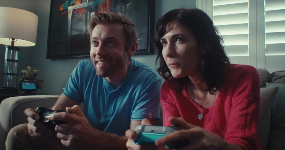 A man and women talk while playing video games at home