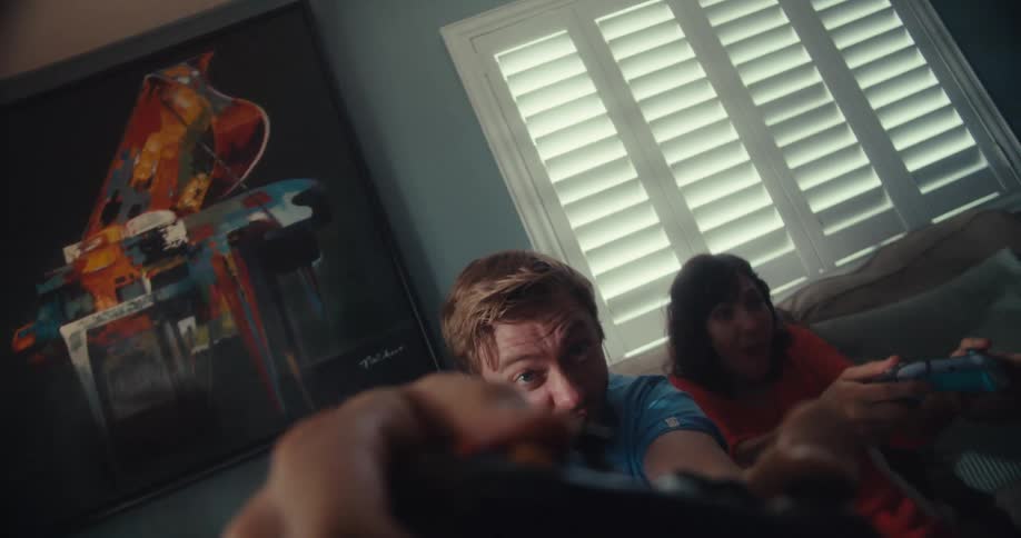 Friends play a computer game while sitting in their living room
