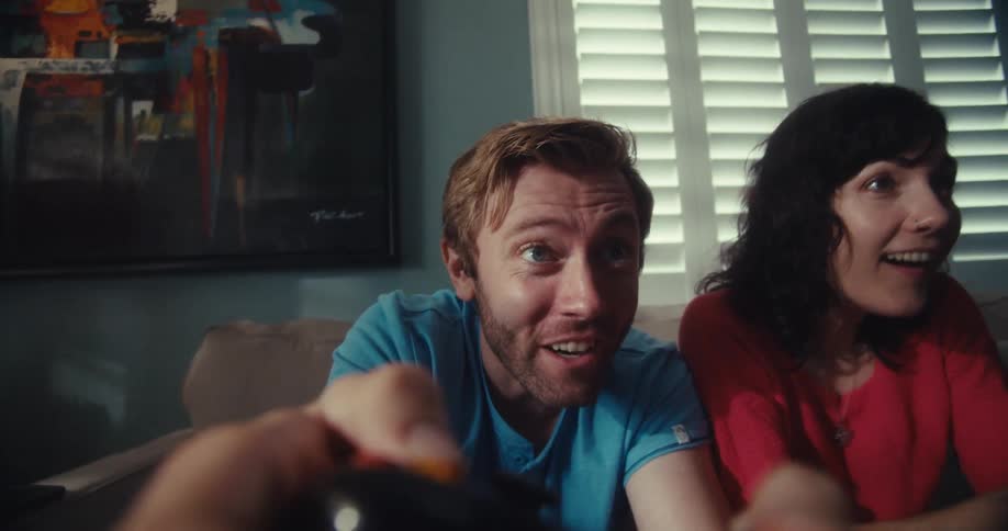 A man and woman cheer as they play video games together