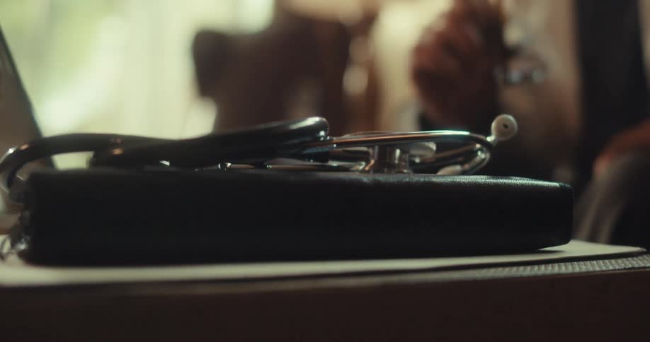 A doctor is talking to someone on his laptop