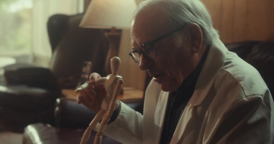 The man is talking while pointing out parts of a small model