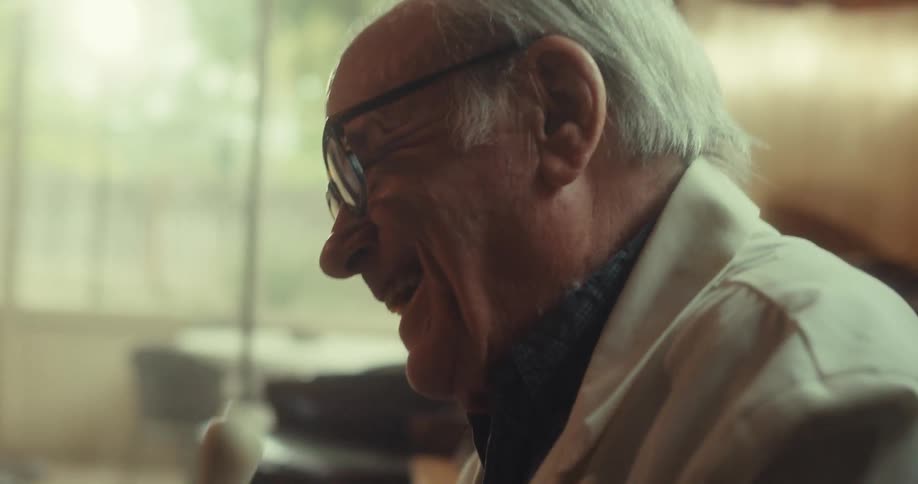 A doctor is laughing while holding a small model and talking