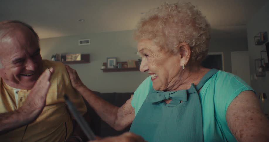 A man and woman laugh and high five each other